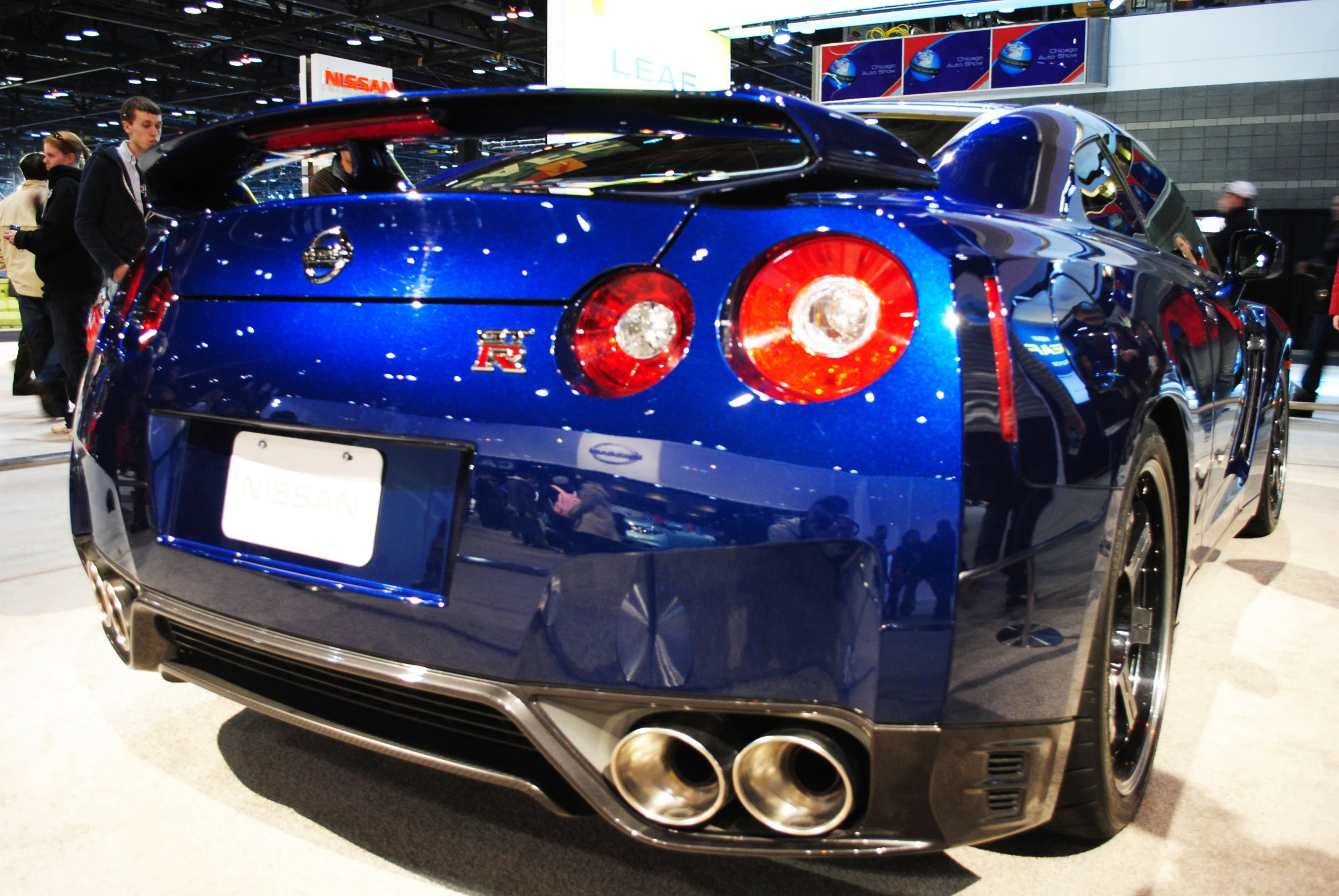 the rear end of a shiny blue car on display