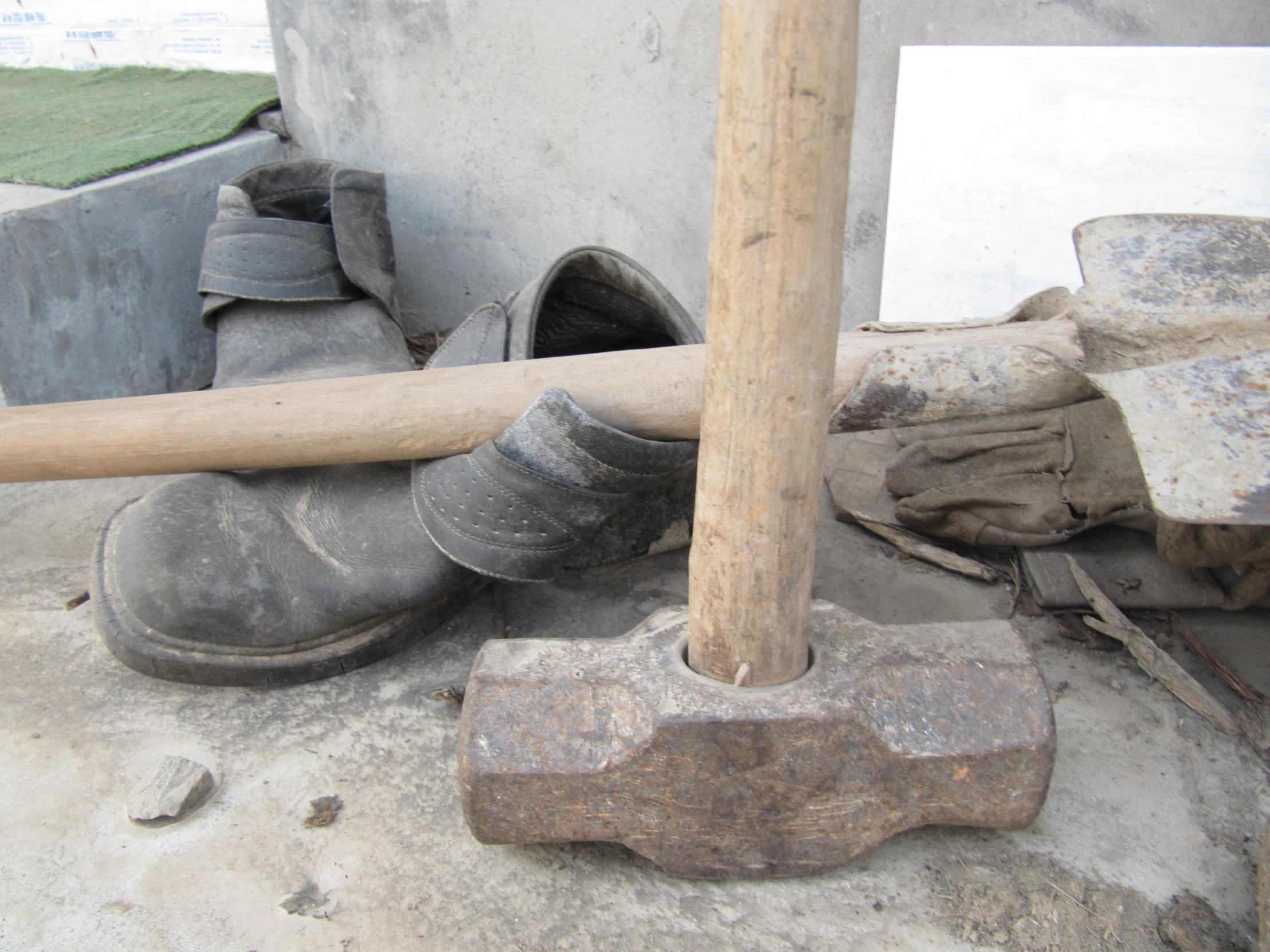 a wooden baseball bat next to some old shoes