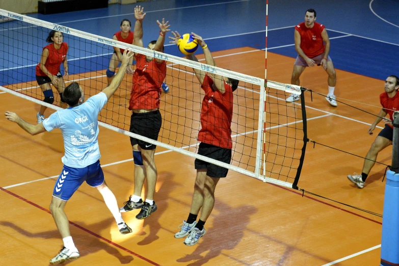 four men are playing volleyball together on a court