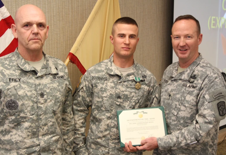 a group of three soldiers holding up a certificate