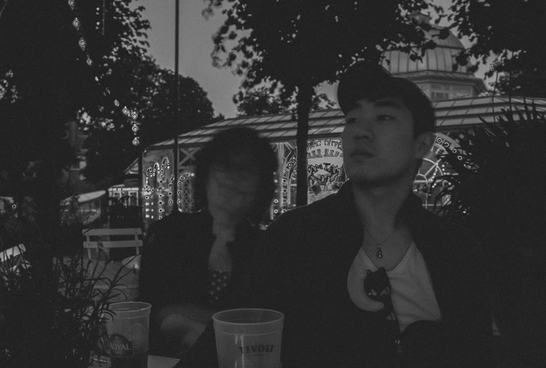 black and white image of two young men looking out the window