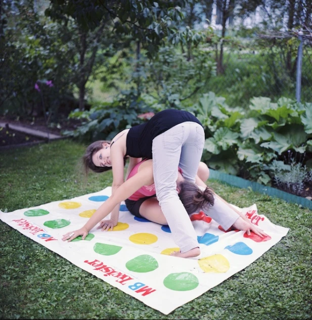 two young women stretch out on a colorful and decorative mat