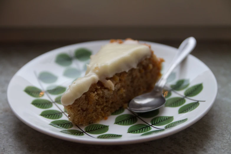 a piece of carrot cake on a flowered plate with a fork