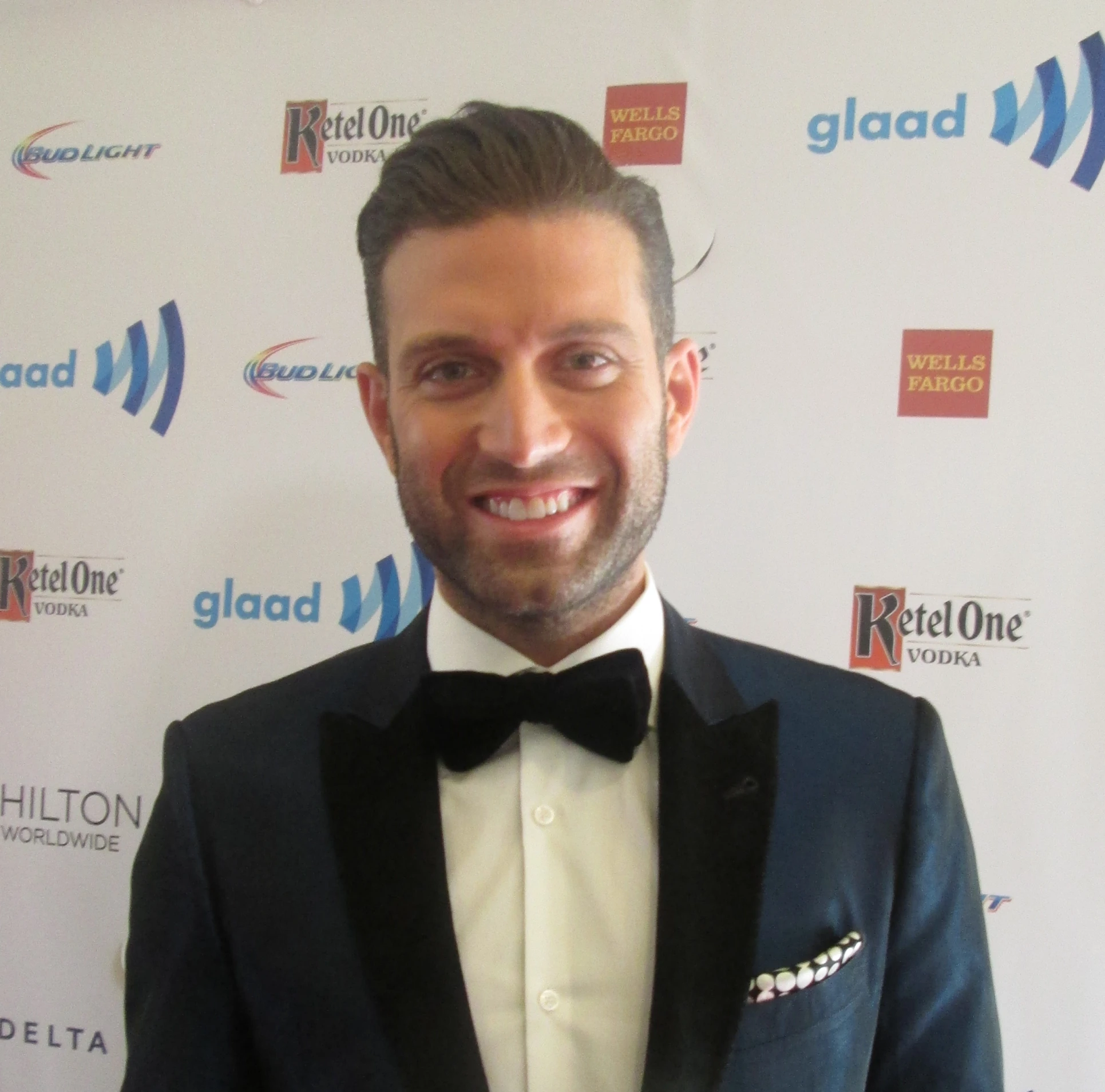 a man in a tuxedo posing for the camera