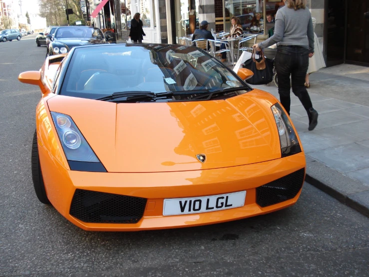 a orange car parked on the side of the road