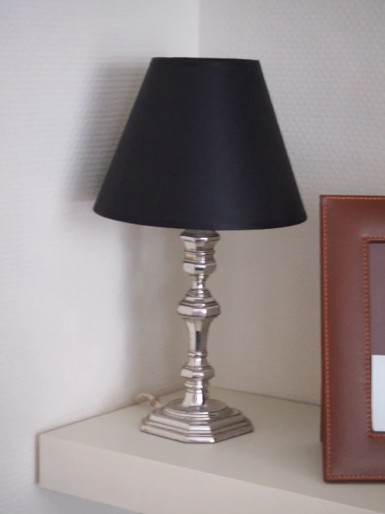a lamp sitting next to an image on a shelf