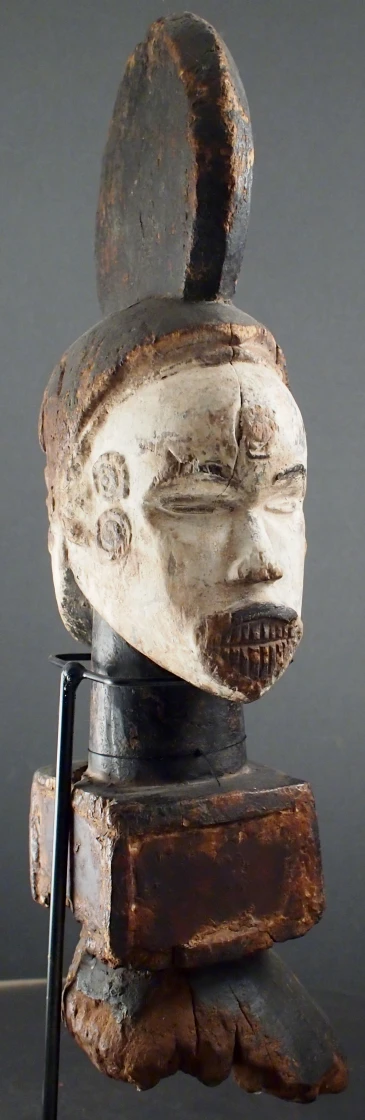 a wooden face on top of a piece of metal