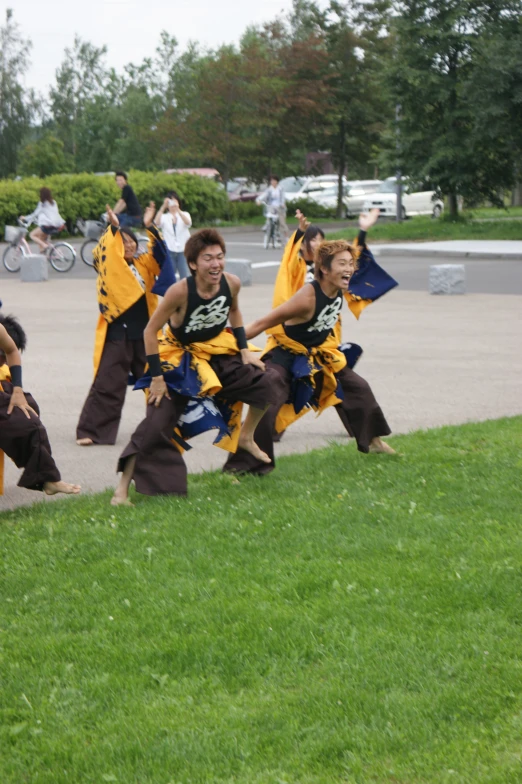 a group of people in brown outfits performing a stunt