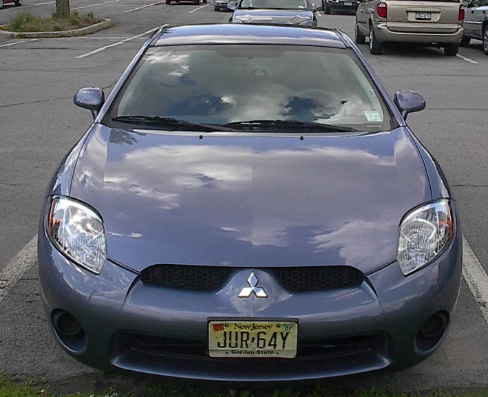a grey compact car parked in a parking lot