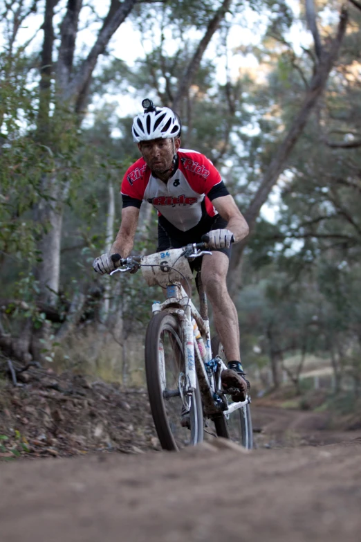 a man riding a bike on a dirt road