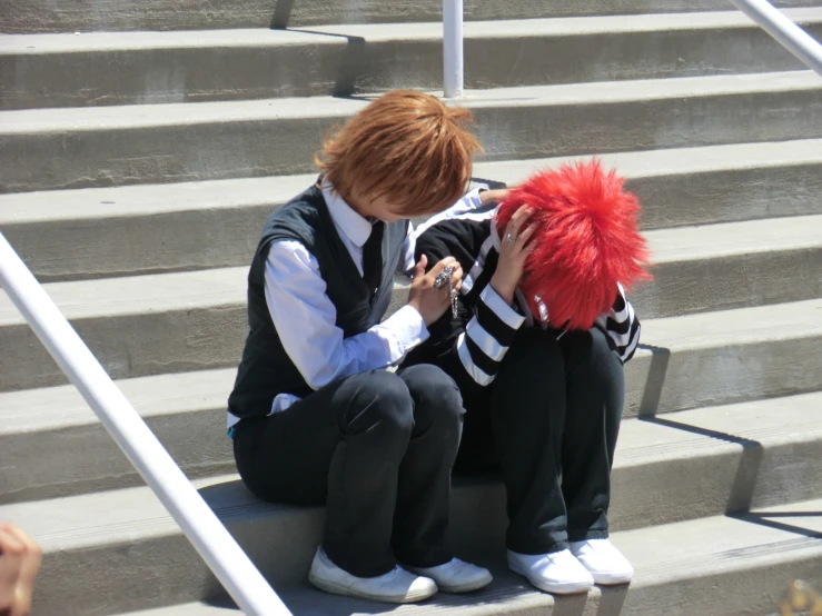 two people in black and white clothes are sitting on some stairs
