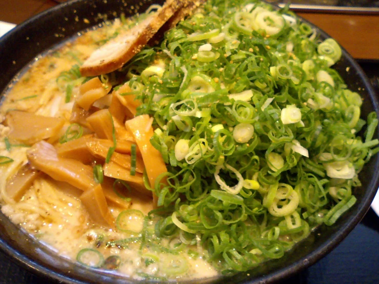 vegetables and bread in a brown bowl on a black counter