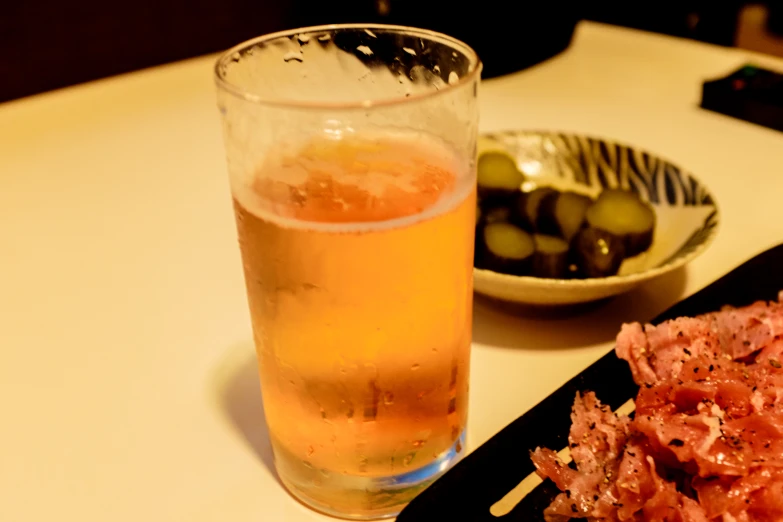 a glass of water sitting next to an empty plate of food