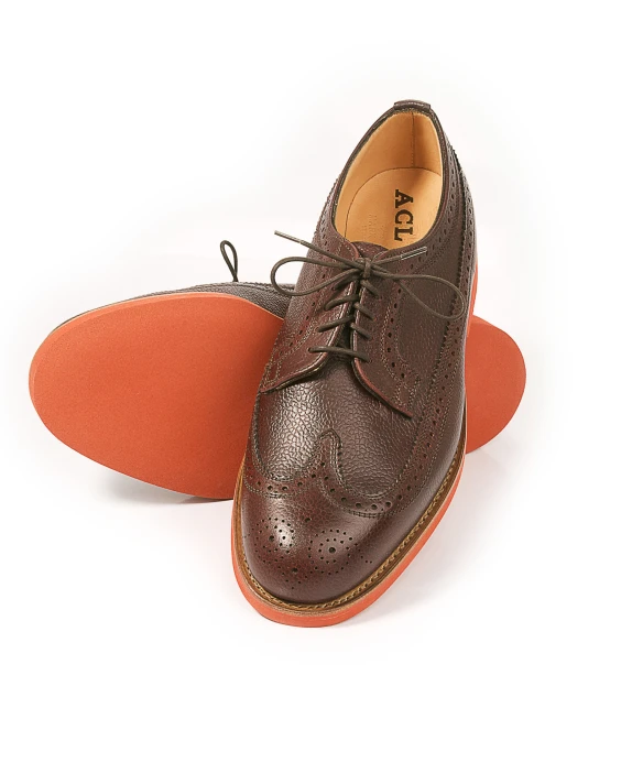 a brown shoe with orange soles