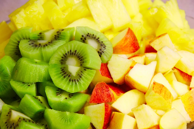 sliced fruit salad contains kiwi, apple, peaches and other fruits