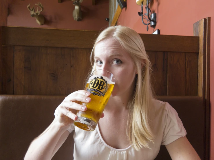 the woman has a beer in her glass while staring at the camera