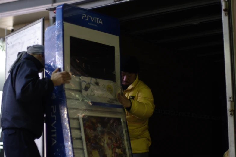 a man holding onto a vending machine with its door open