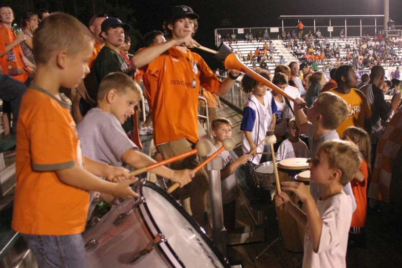 a group of boys playing drums at a soccer game