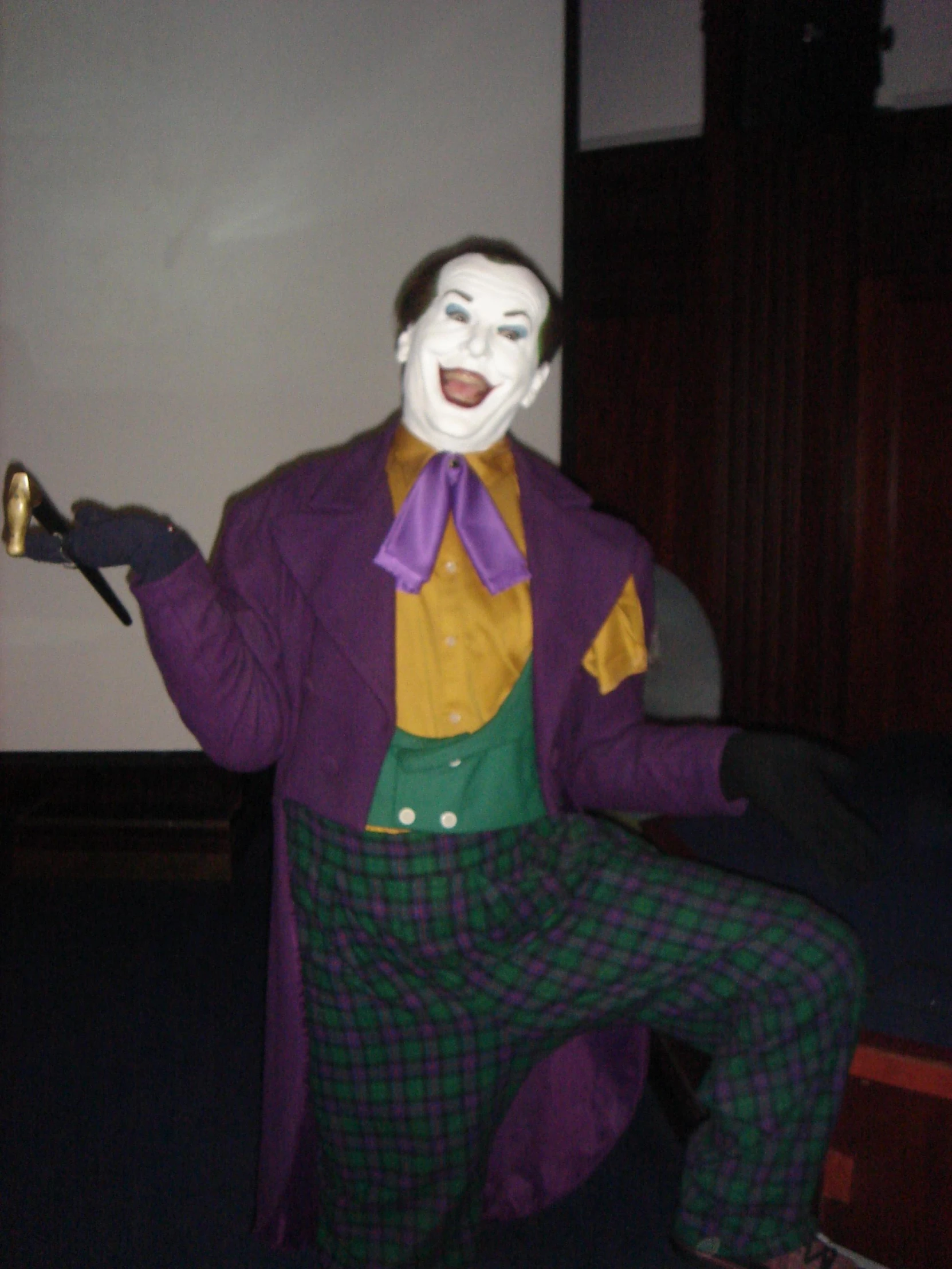 a man wearing a purple and yellow costume is holding up soing