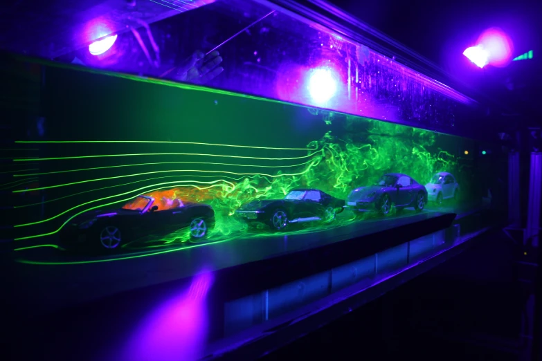 the view of an event with neon lighting on the cars