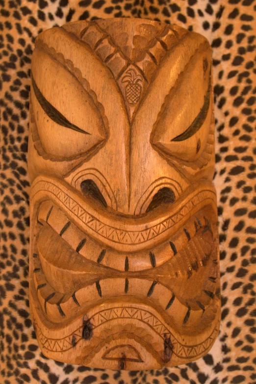 a wooden mask on a leopard skin wall