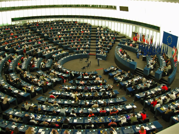 a huge room with people seated at round tables