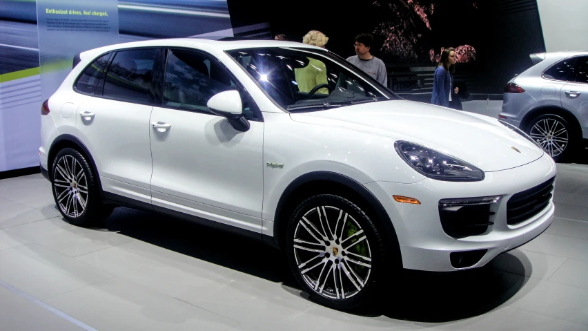 the front end of the white porsche cayen turbo is shown at an event