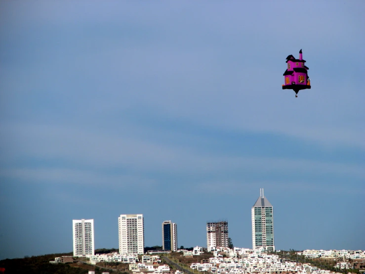 a kite flying over a city and tall buildings