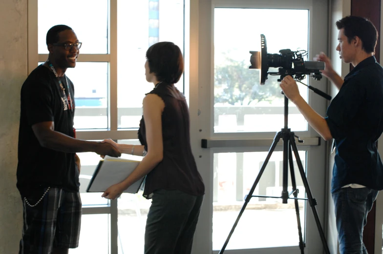 a man and woman in front of a window near a camera