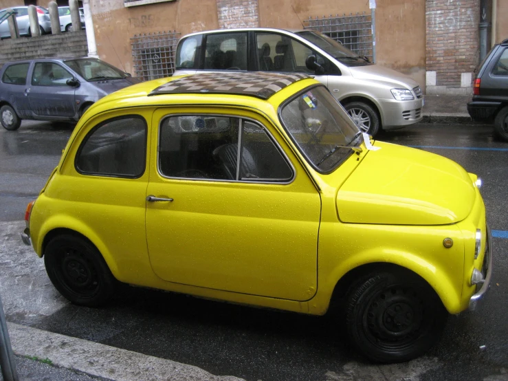 an old, yellow car is parked on the side of the road