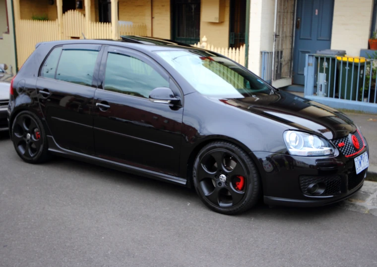 a black car parked in front of a yellow building