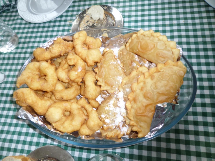 an abundance of fried and doughnuts on a glass plate