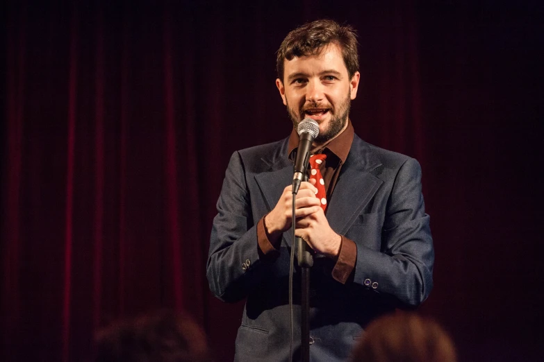 a man standing on stage holding a microphone