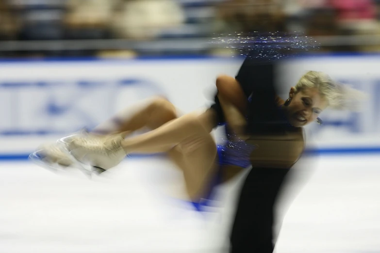 a couple of women skating on top of a ice covered rink