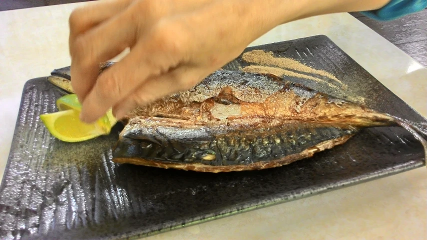 someone is slicing a fish on a  board