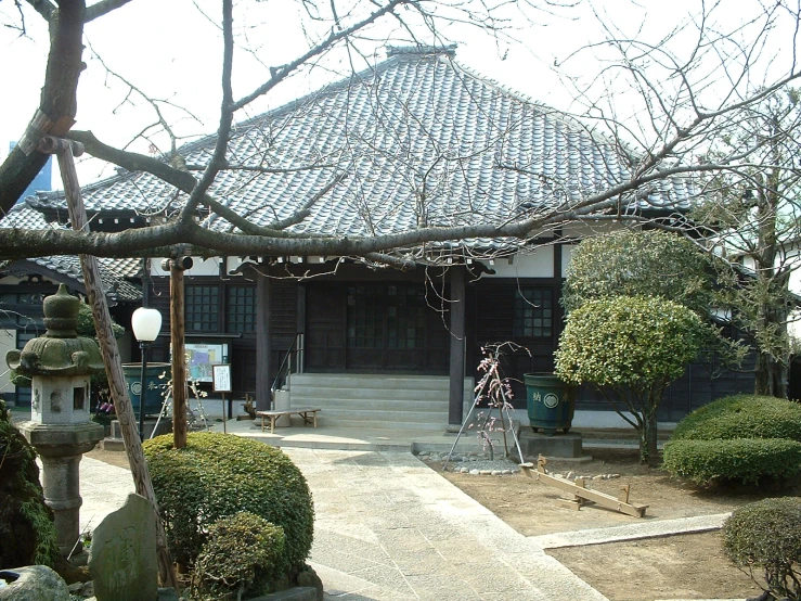 a garden area with hedges and a gazebo in the background