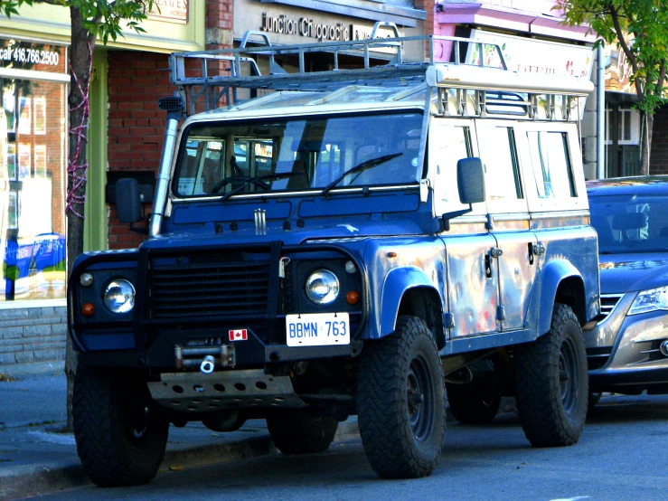 a land rover is parked along a busy street