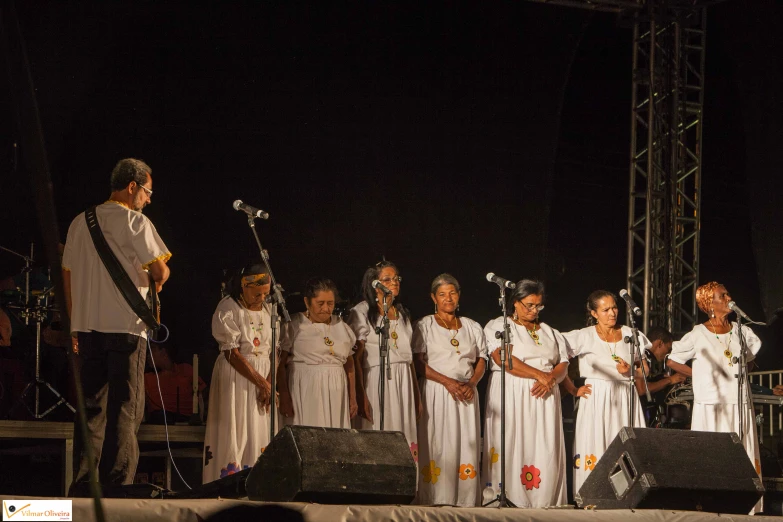 a man playing a guitar in front of a group of people