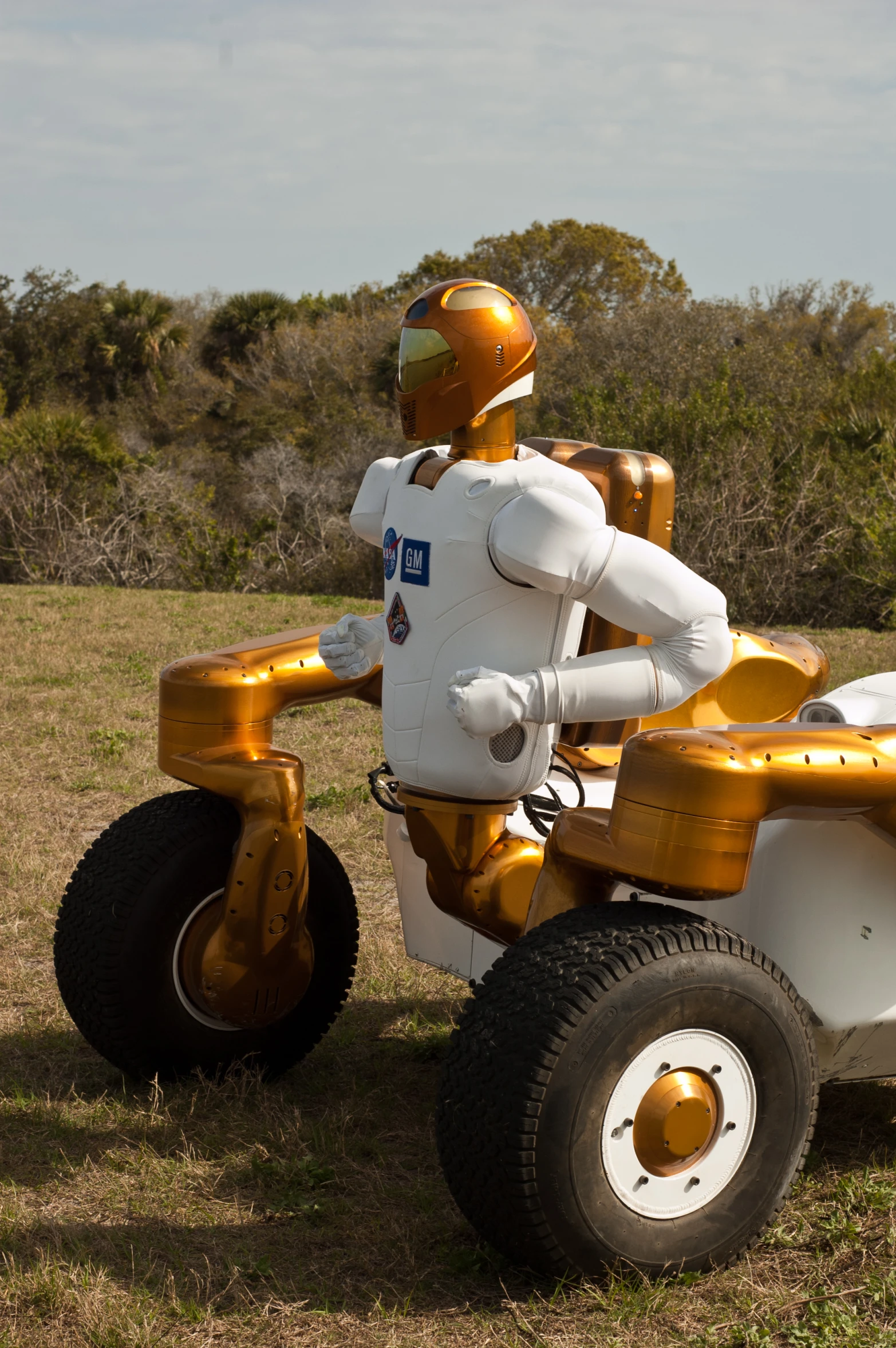 the robot rides a yellow and white quad bike