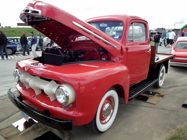 an old red truck with a big hood