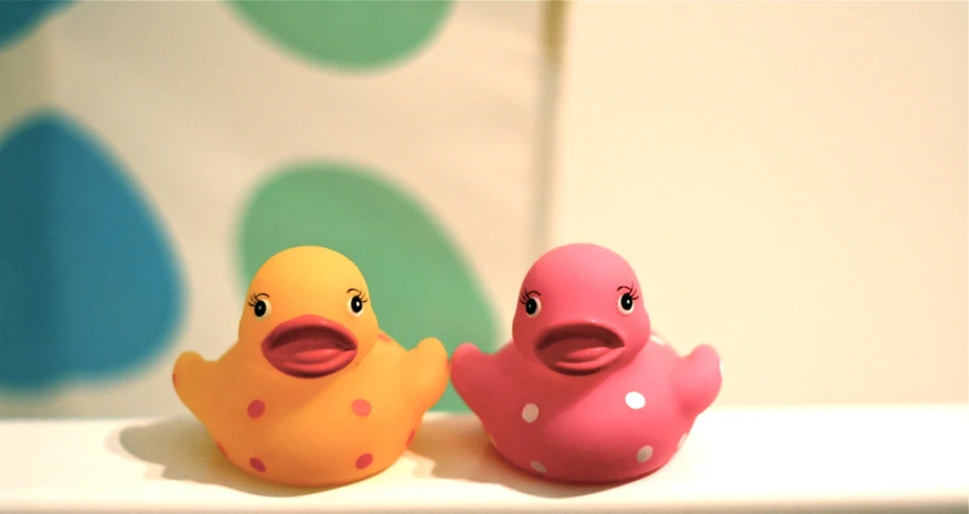 two little plastic toy ducky toys sitting on top of a table