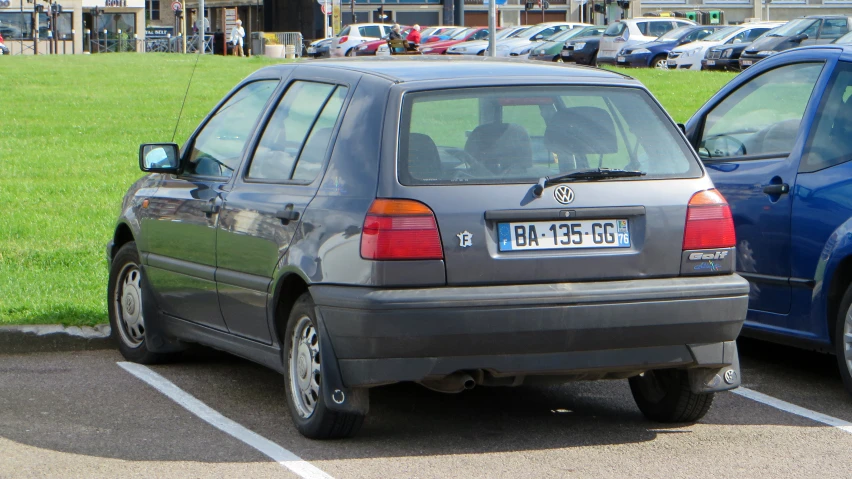 the back end of two cars parked in the lot