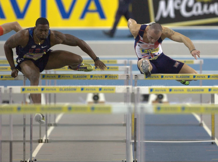 a male competitor and an unknown person trying to get over a hurdle