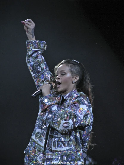 singer wearing patterned outfit performing with microphone in air