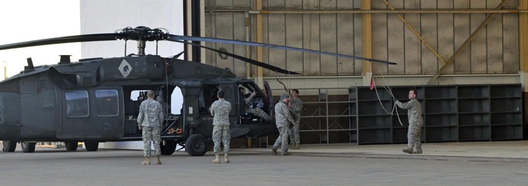 soldiers in uniform stepping into a black helicopter