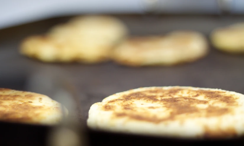 pancakes cooking on the stove being cooked in a frying pan