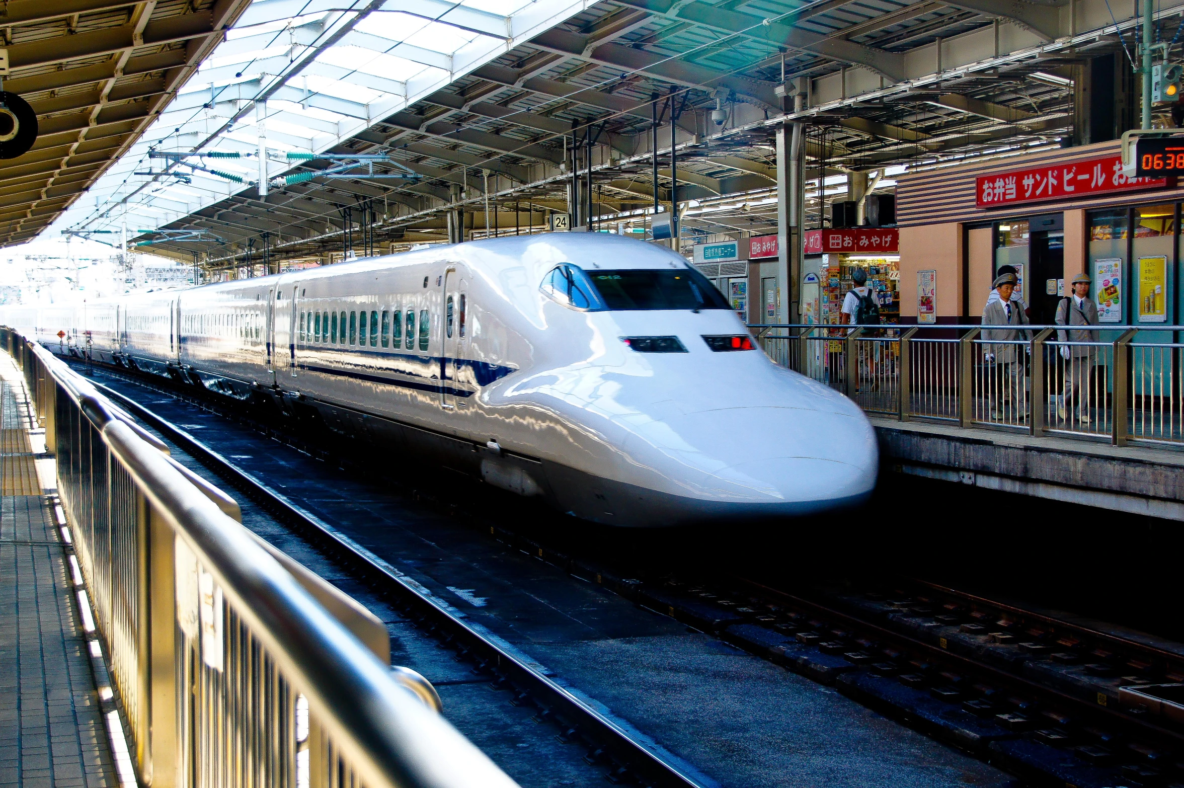 a white bullet train pulls into a station