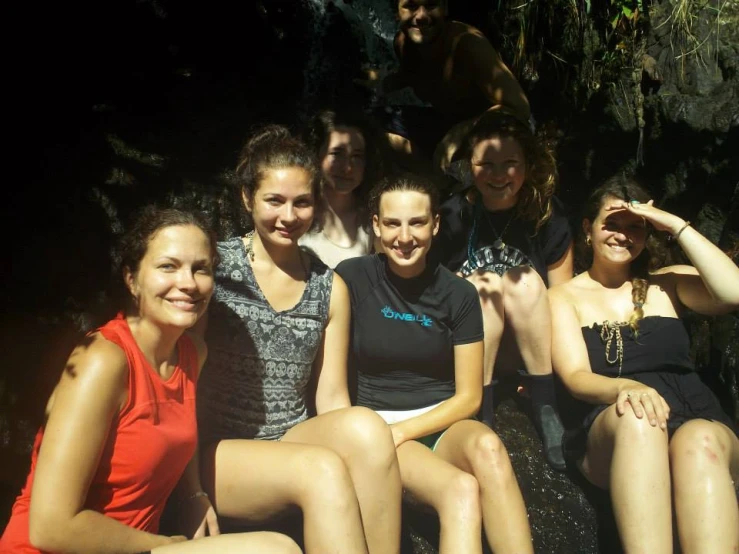 several women in dresses sitting next to each other and posing for the camera