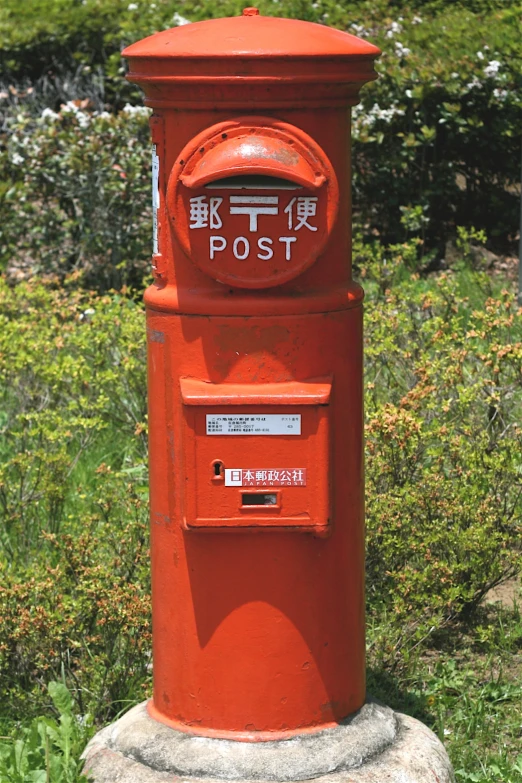 a red post box on the edge of a lawn