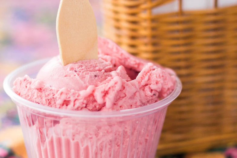 a pink colored cup with a wooden paddle sticking out